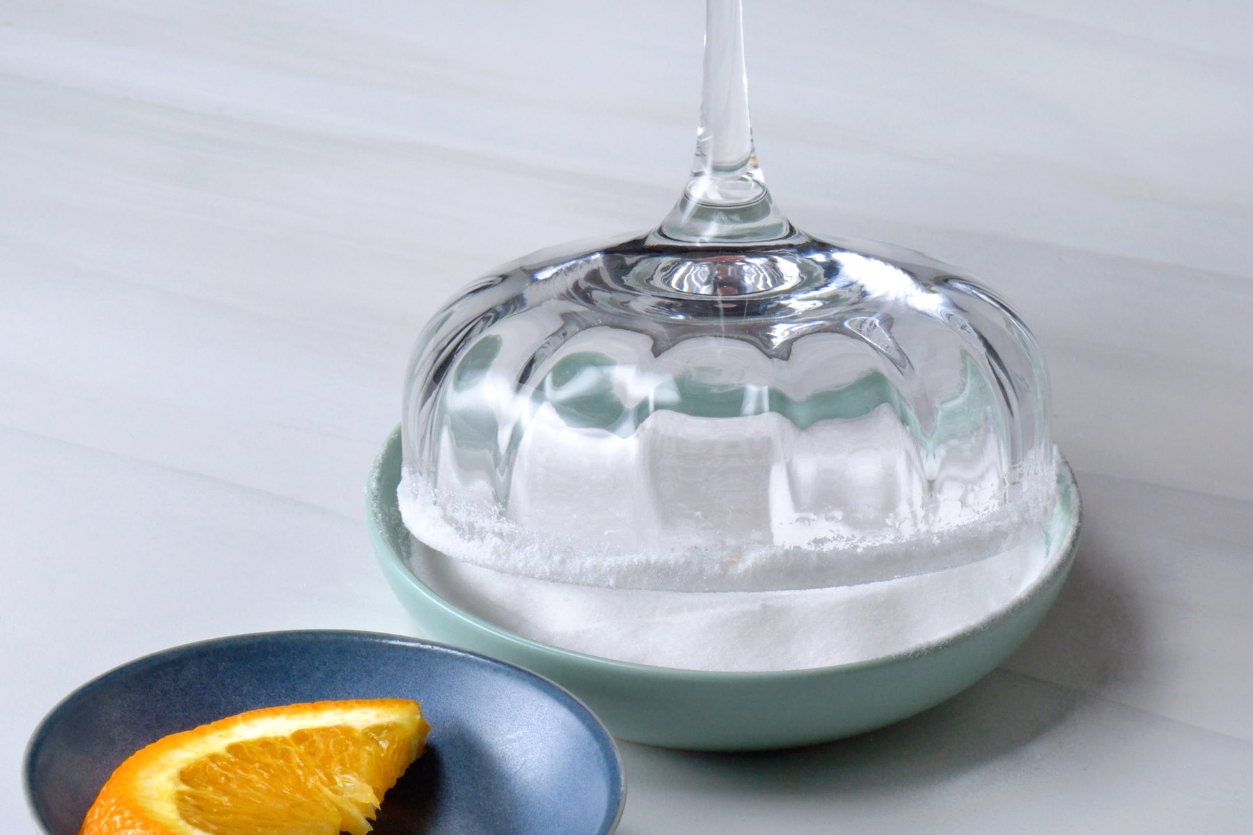 Gently pressing the rim of the coupe glass on fine sugar kept in a small bowl