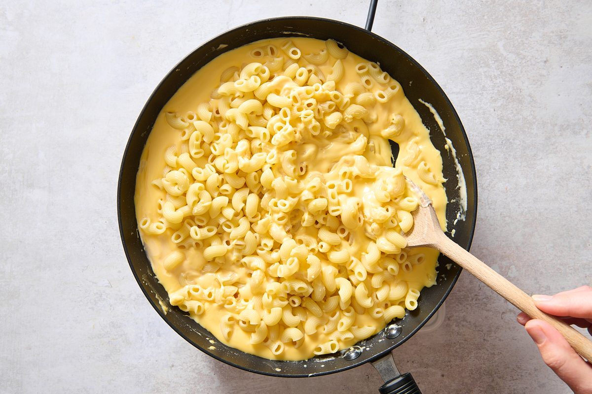 Stirring pasta into the sauce in the skillet