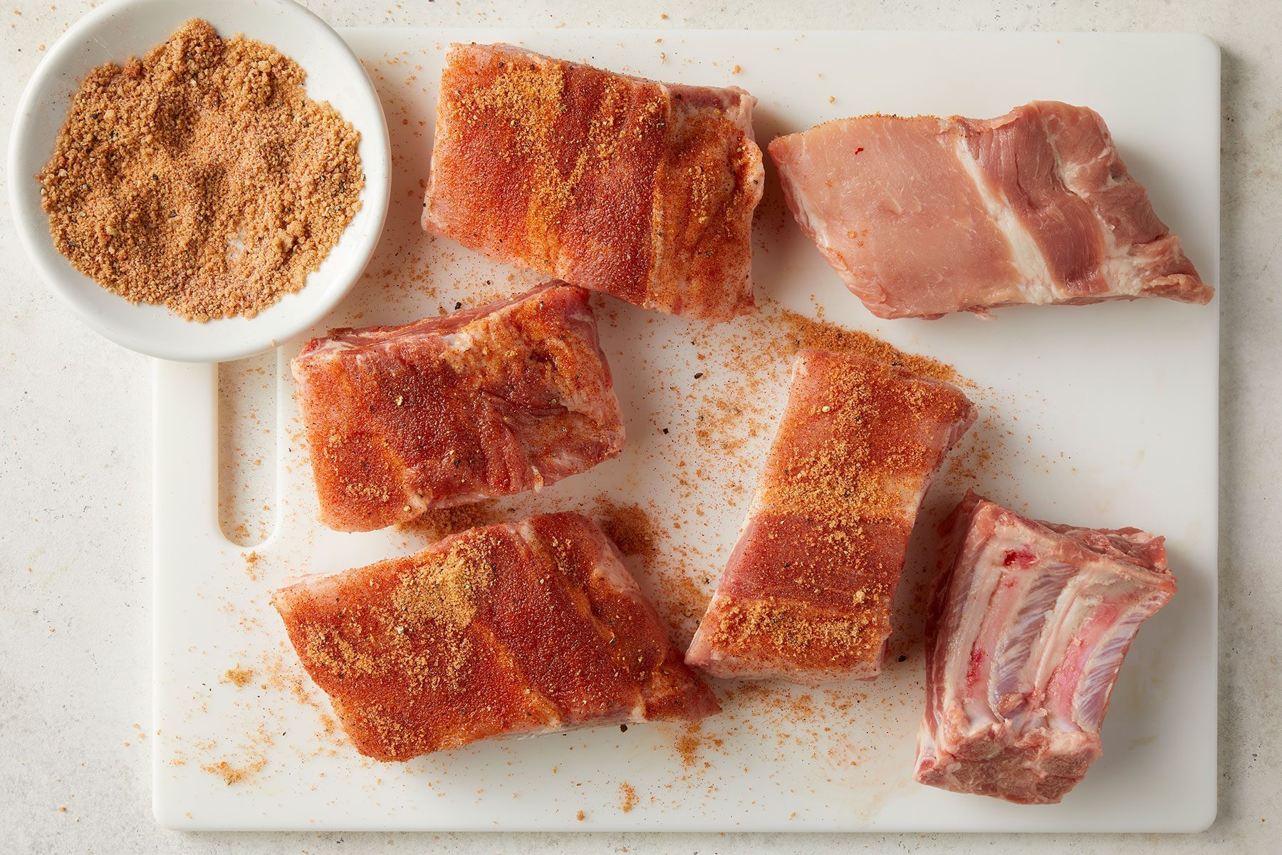 Overhead shot of all ingredients; ribs; white chopping board; marble background