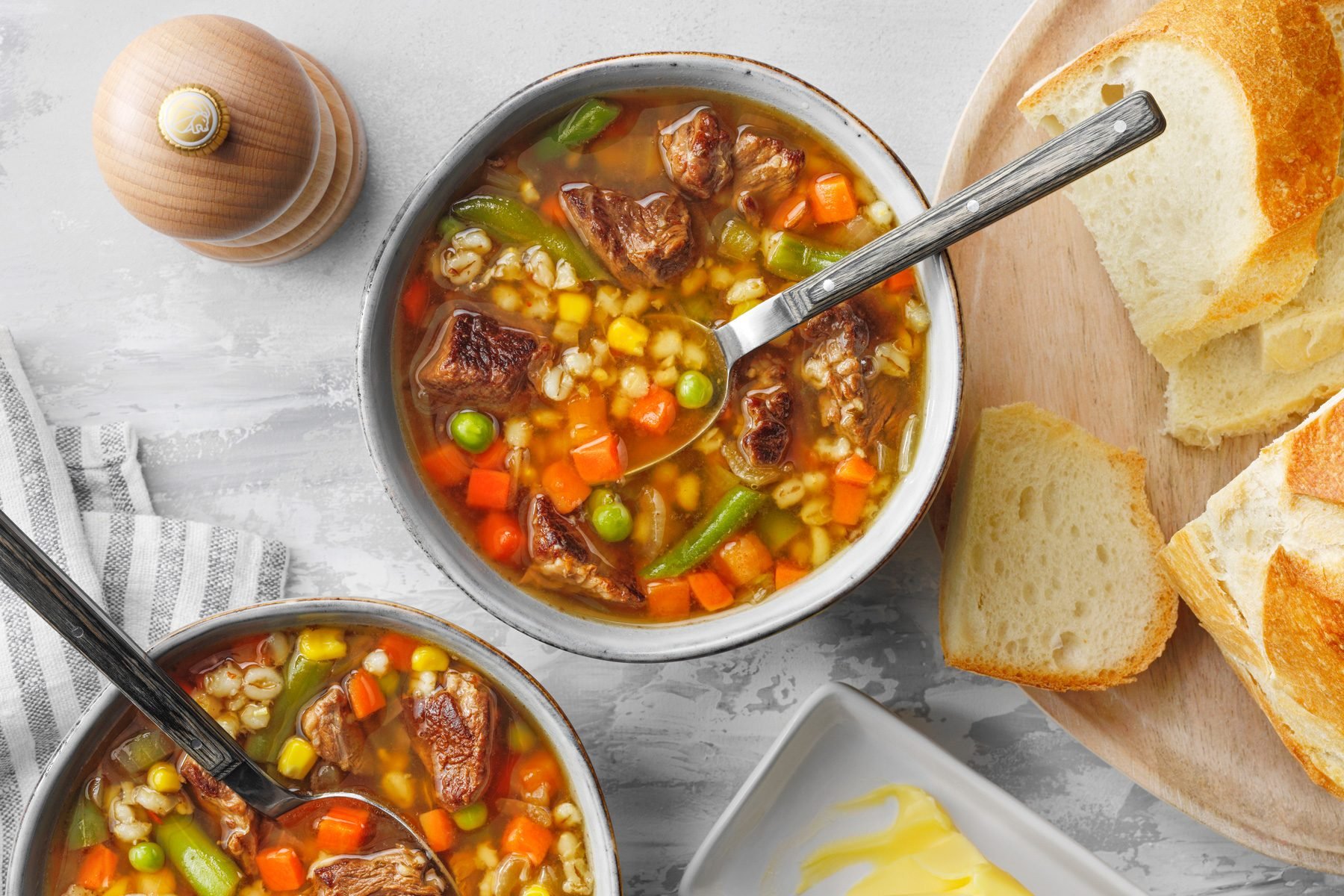 Slow Cooker Beef And Barley Soup in soup bowls served with bread