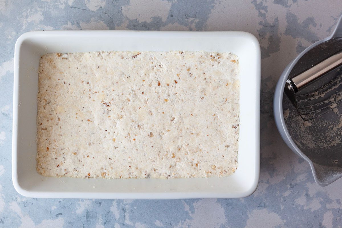 Step 1 of Taste of Home Sweet Potato Cheesecake Brownies is to make the crust by combine cake mix, butter and pecans before pressing into the bottom of the pan