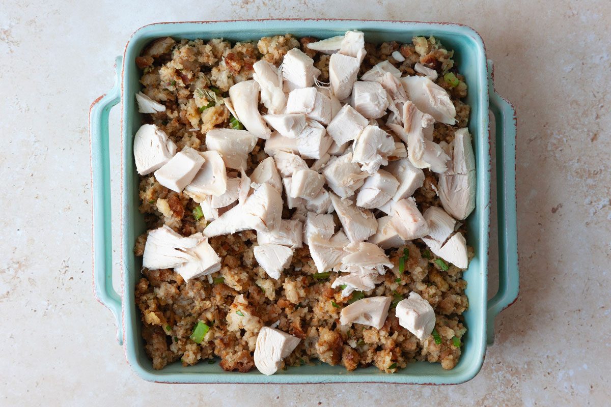 Step 1 of Taste of Home Turkey Stuffing Casserole is to combine the stuffing with parsely and transfer to baking dish before topping with cooked chicken