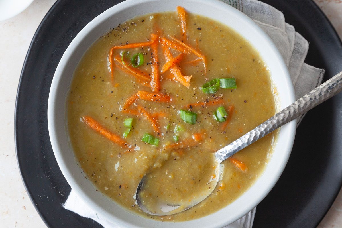 Single serving of Taste of Home Vegetarian Split Pea Soup garnished with shredded carrots and sliced green onions