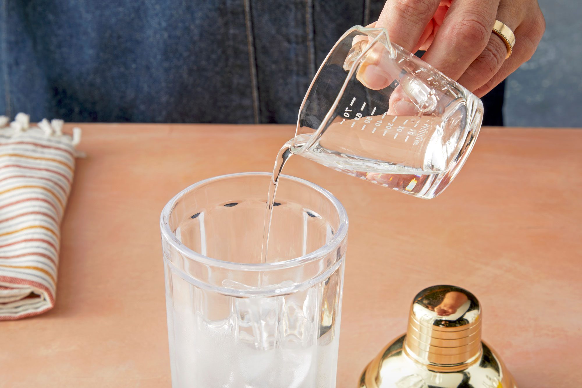 3/4 angle view shot of adding schnapps; kitchen towel; light orange background;