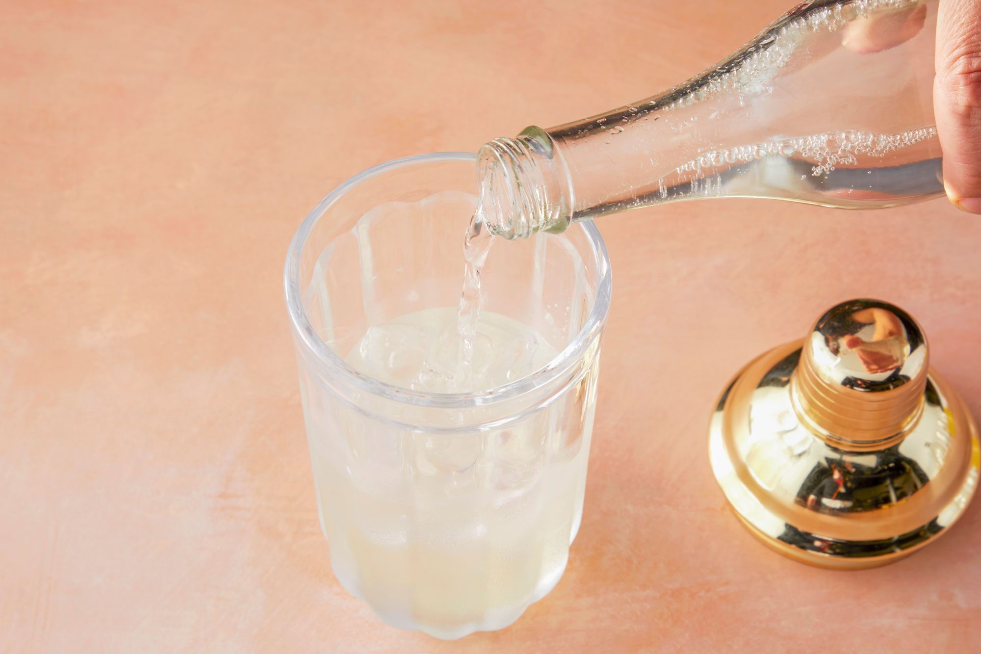 Top view shot of adding soda; light orange background;