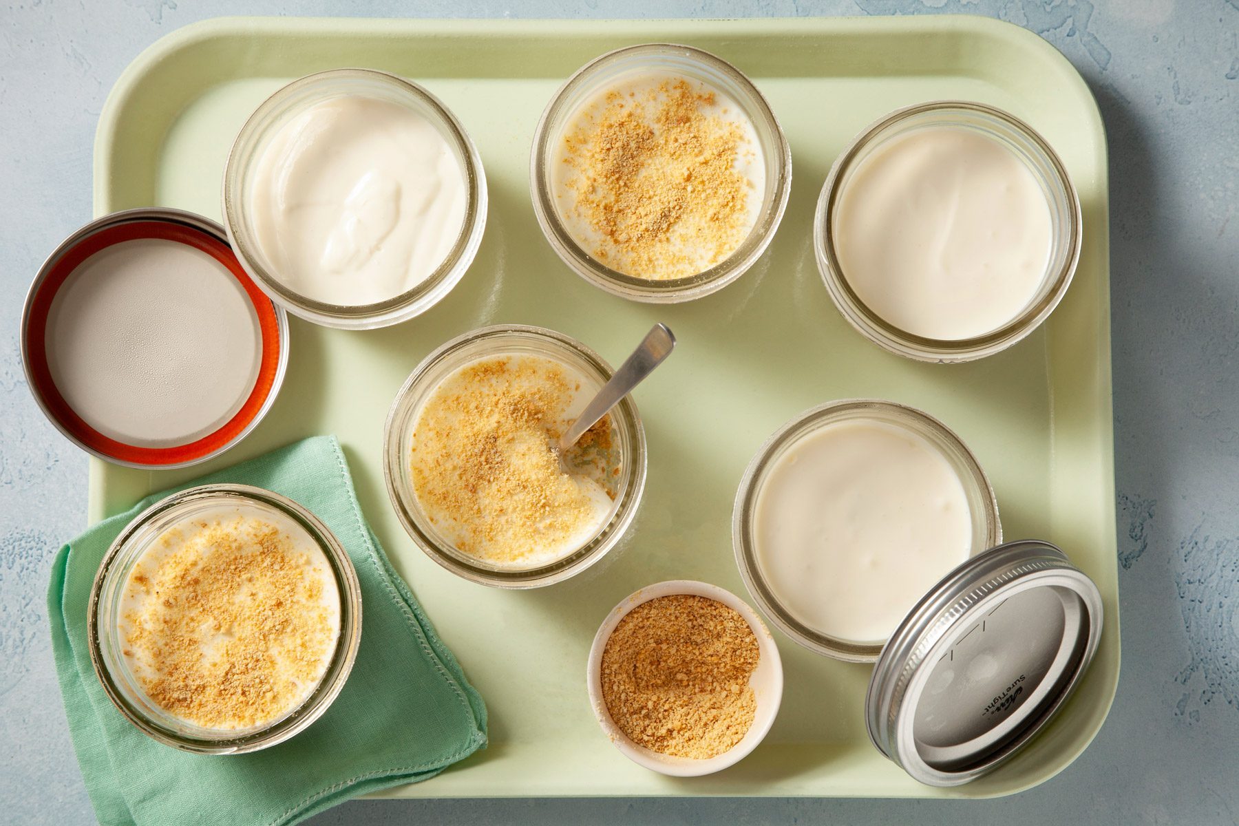 Glass jars containing cheesecake are on a tray.