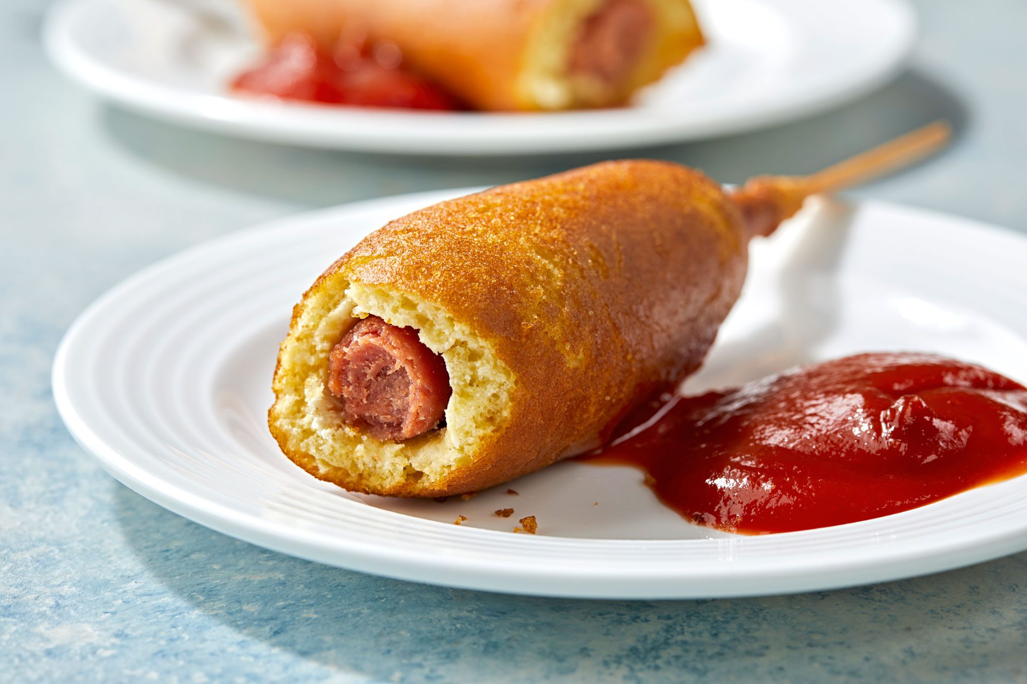 Air Fryer Corn Dogs served in a plate with ketchup