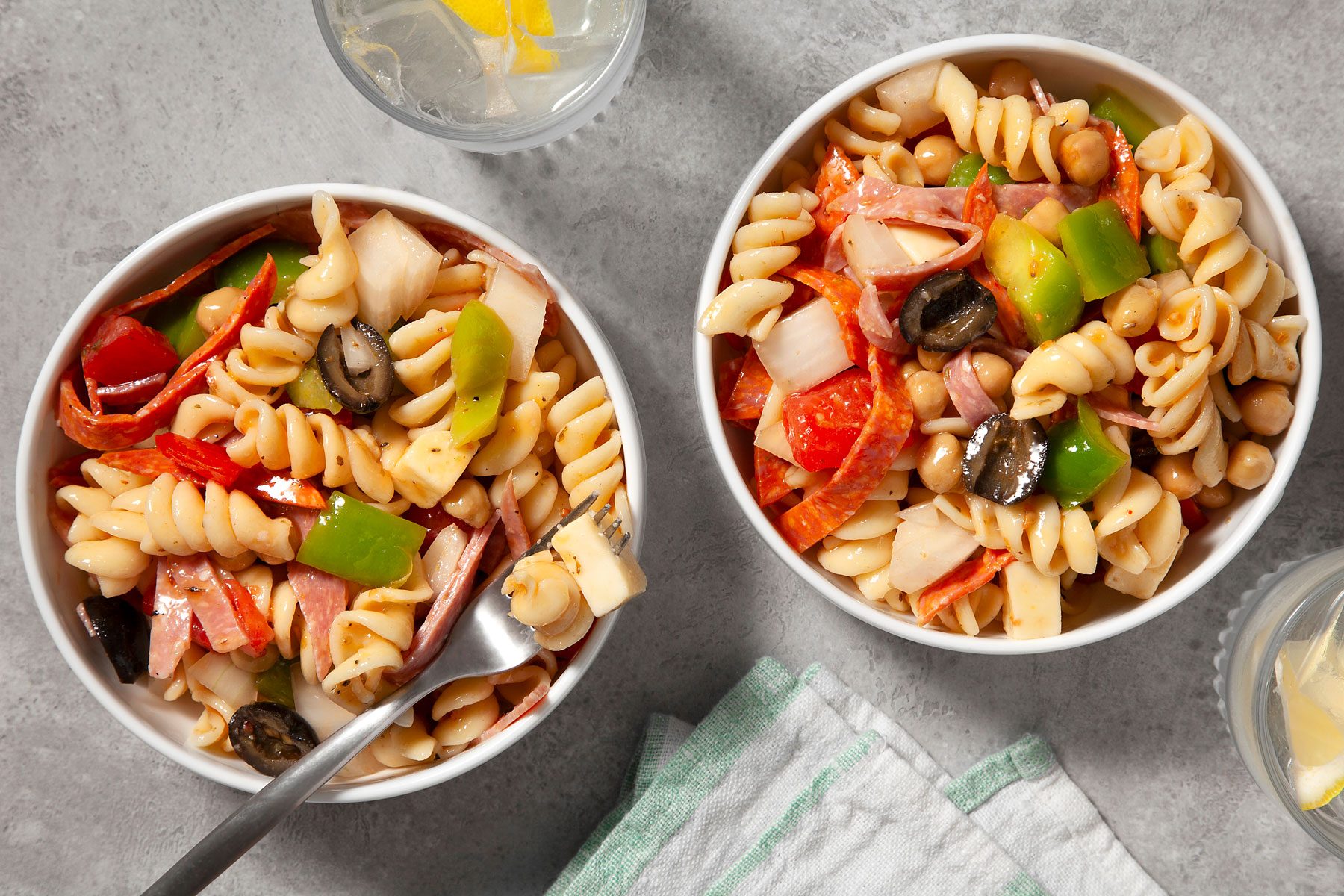 Antipasto Pasta Salad IN 2 bowls. One bowl has a fork in it.