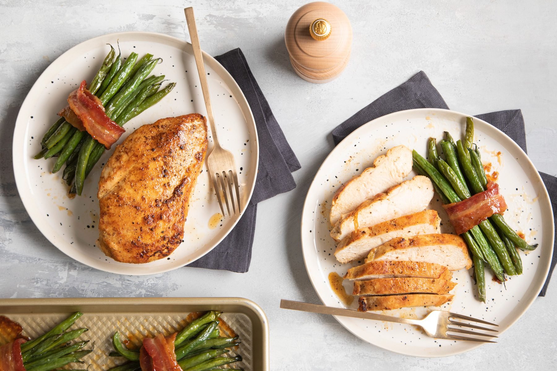 Top shot of bacon wrapped green beans served on plates with meat