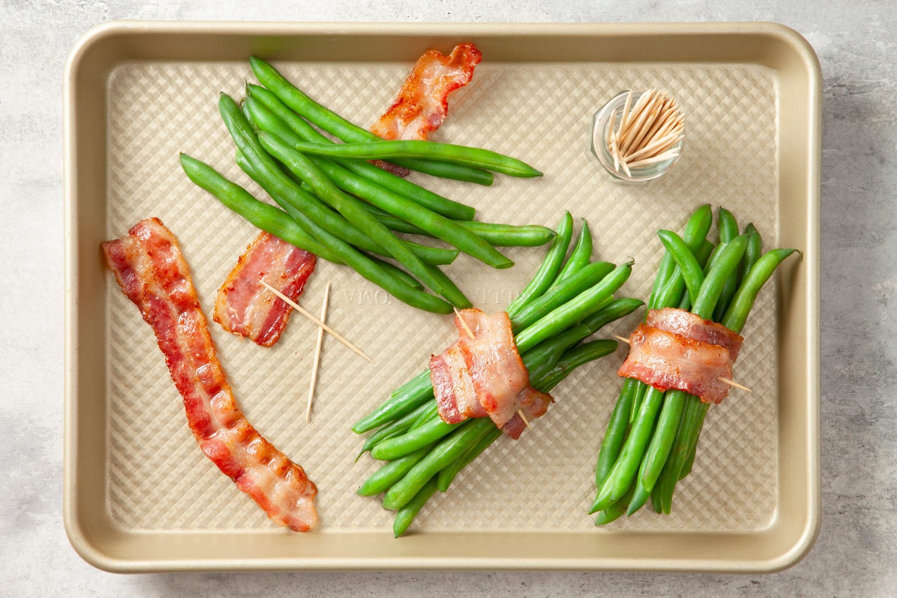 Top shot of beans wrapped with bacon on baking tray