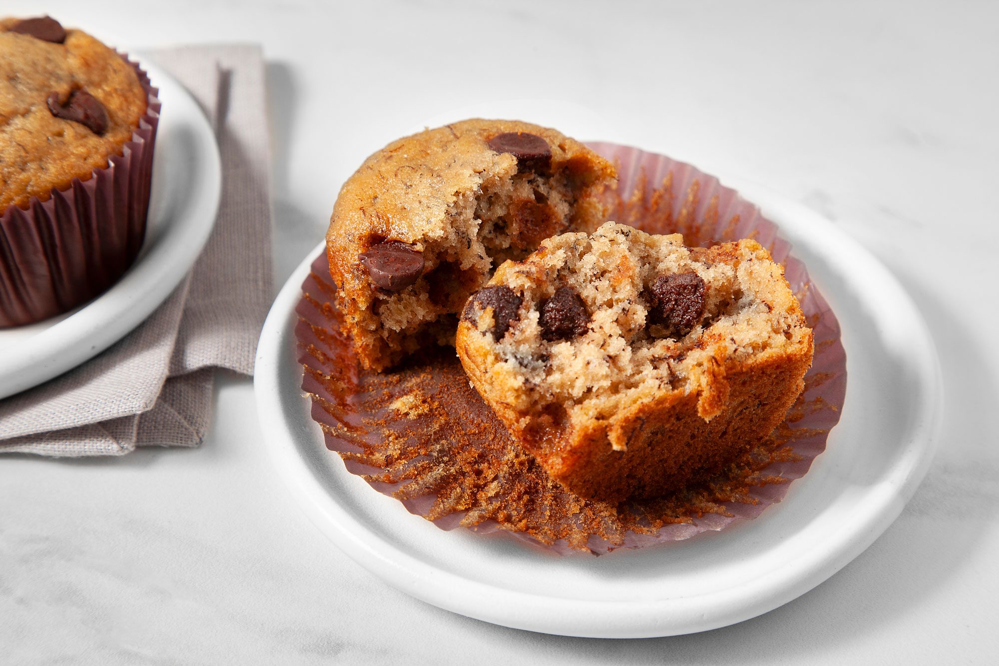 Banana Chocolate Chip Muffins served over two small white plates