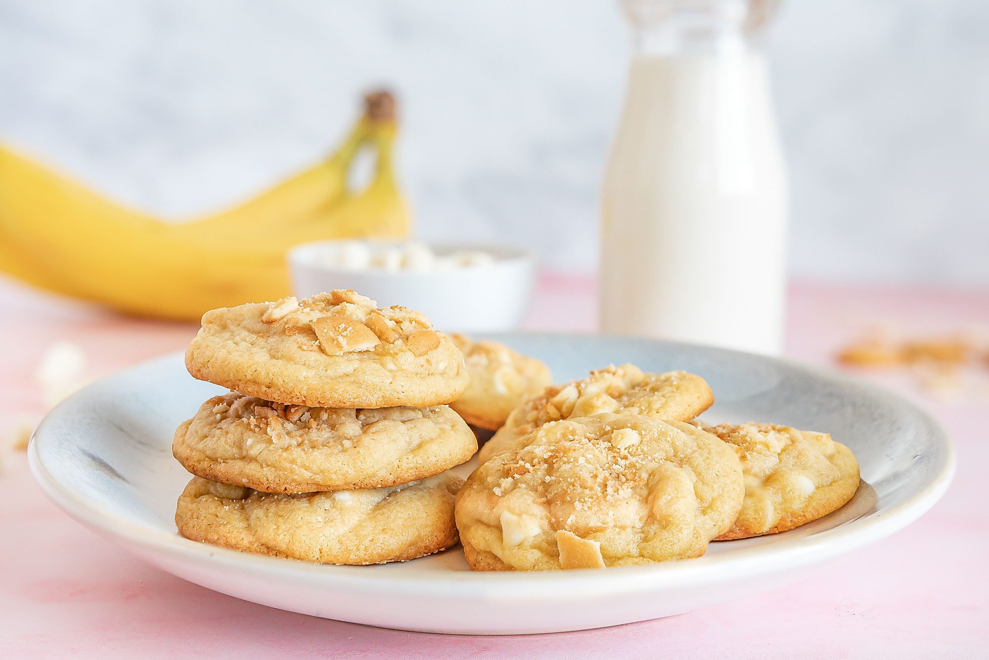 Table view shot of Banana Pudding Cookies; serve on plate with fresh milk; banana; pink texture surface;