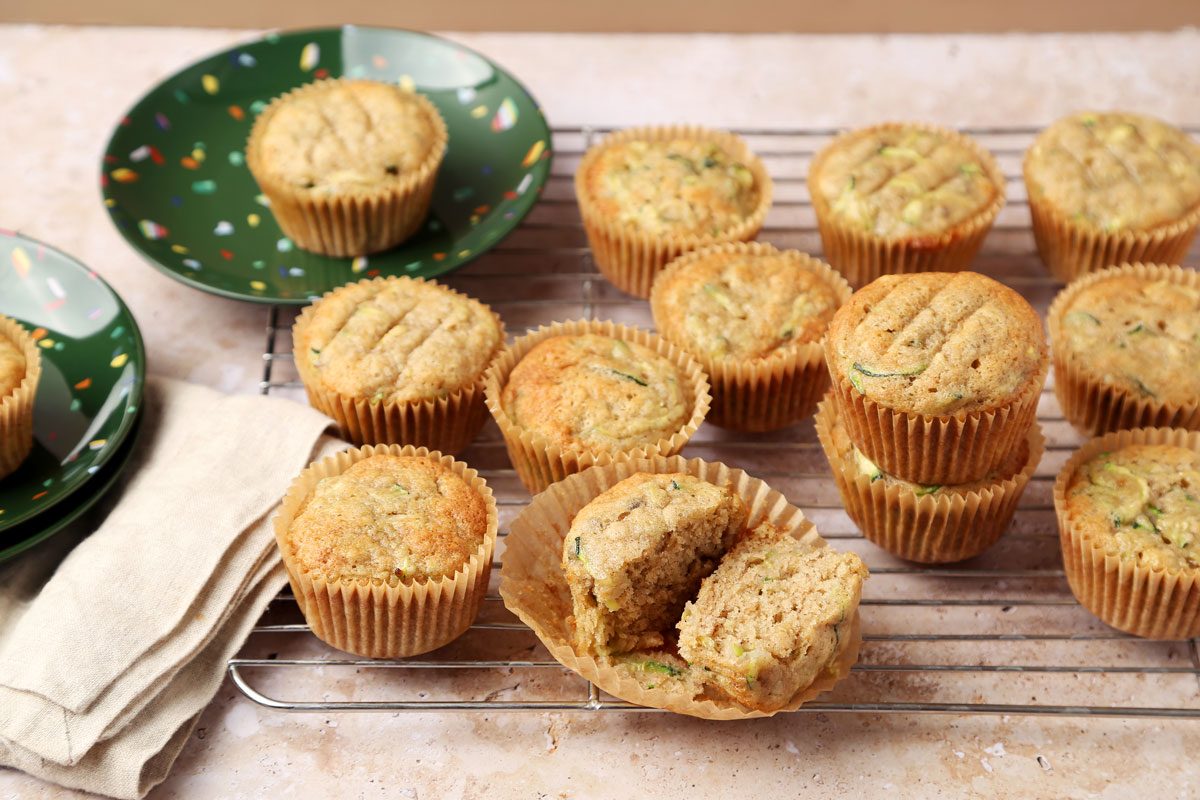 Taste of Home's Banana Zucchini Muffins on green plates and on a cooling rack.