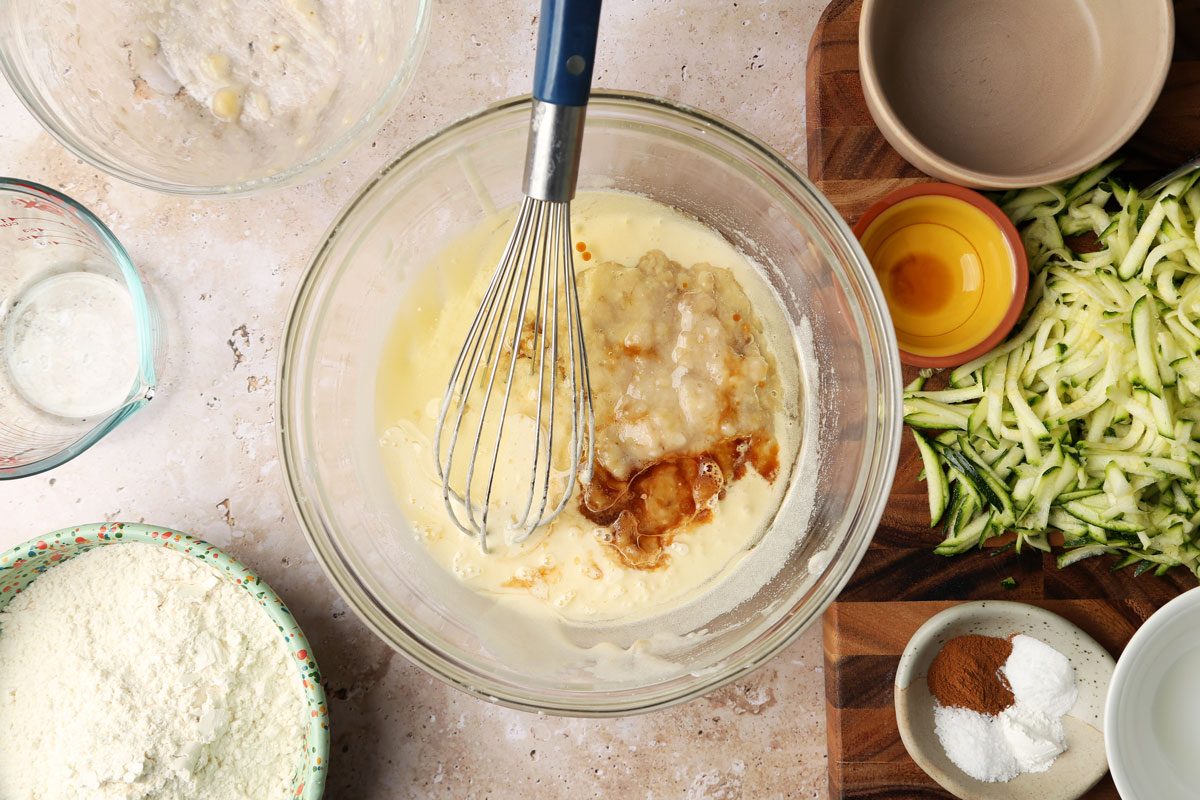 Process shot of Taste of Home's Banana Zucchini Muffins. Making the batter in a mixing bowl with a whisk.