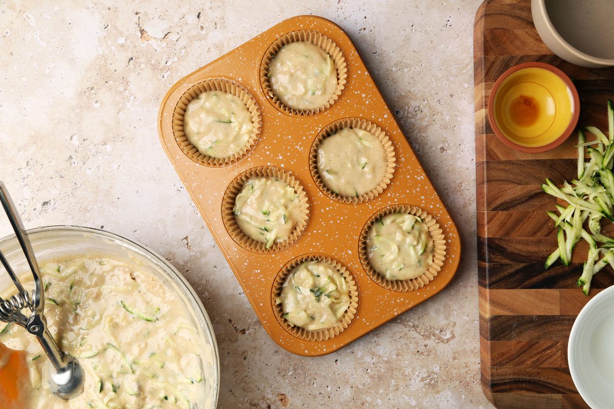 Process shot of Taste of Home's Banana Zucchini Muffins. Batter in muffin tins.