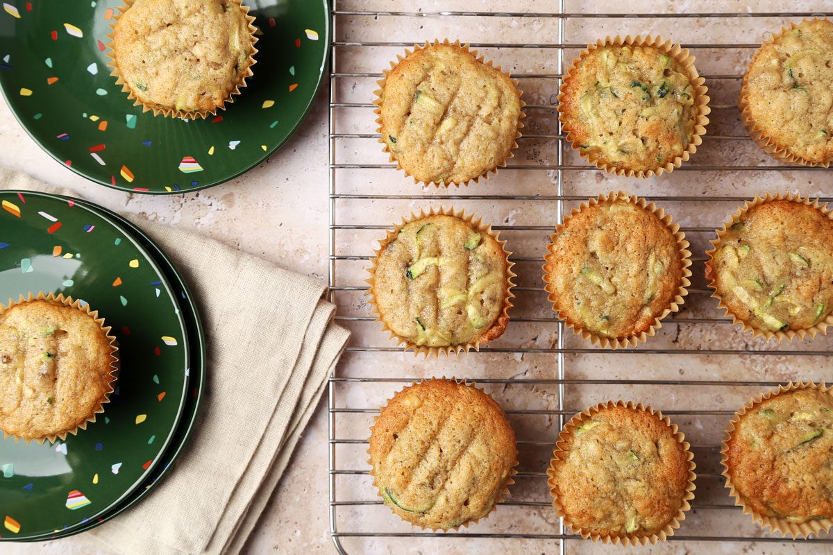 Taste of Home's Banana Zucchini Muffins on green plates and on a cooling rack.