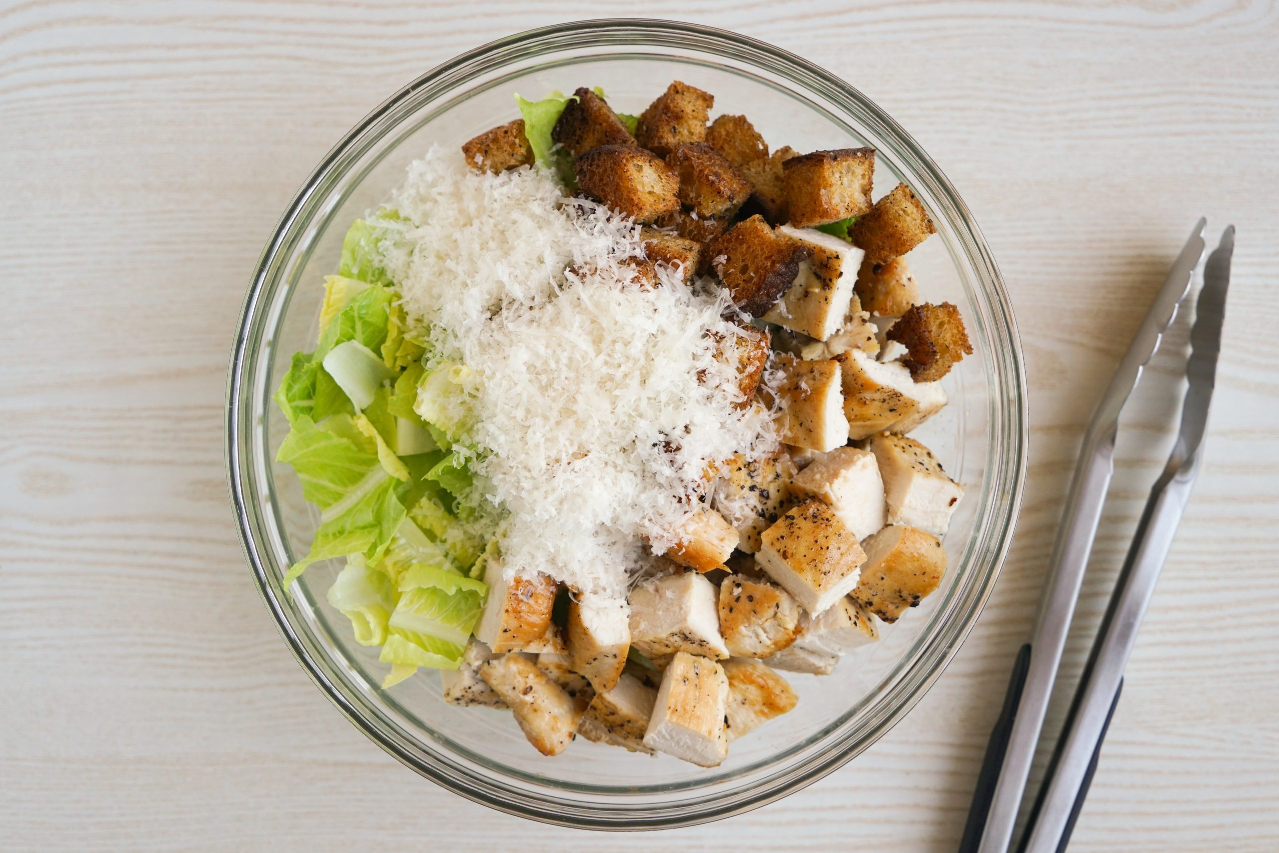 Tossing the chicken caesar salad