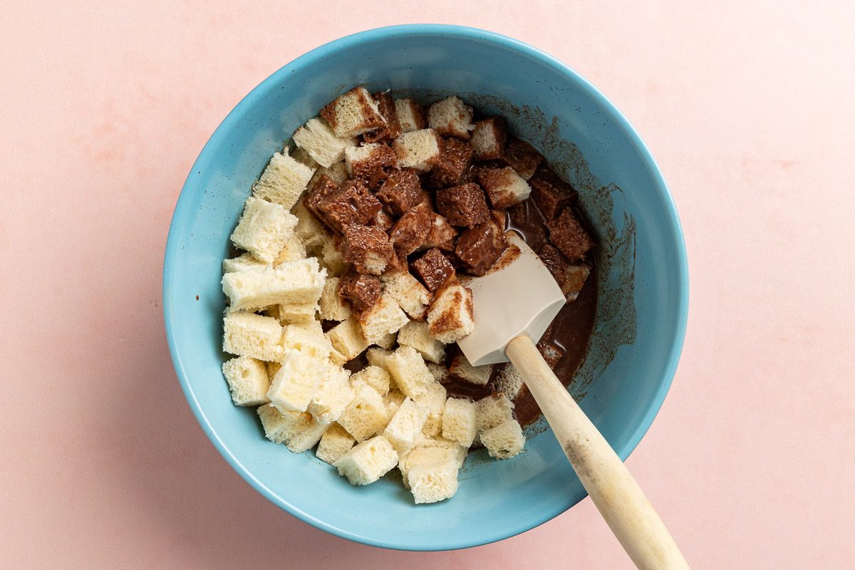 Taste of Home Chocolate Bread Pudding photo of tossing the bread cubes with the chocolate sauce in a mixing bowl.