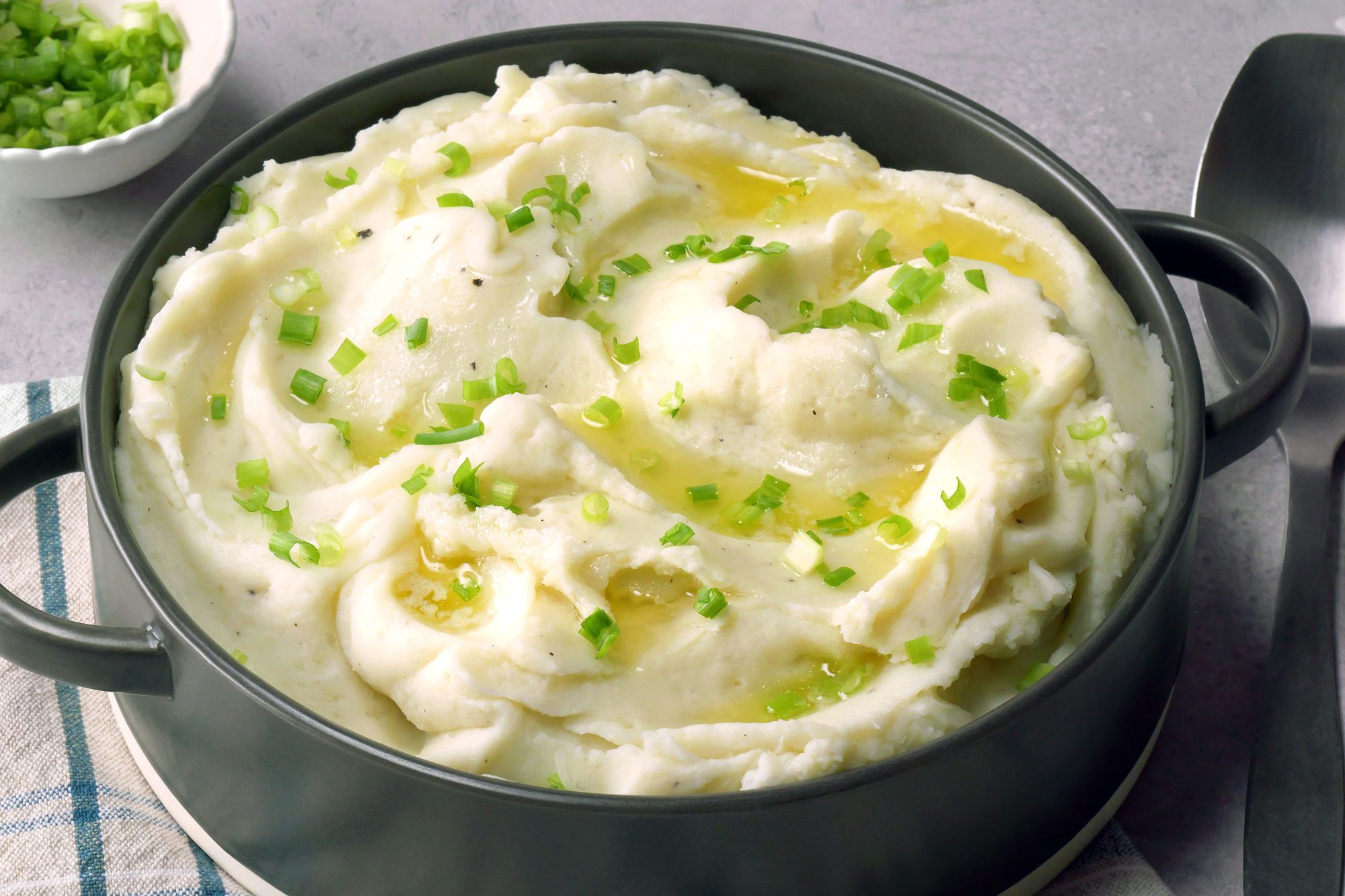 Creamy Mashed Potatoes in a stockpot garnished with green onions