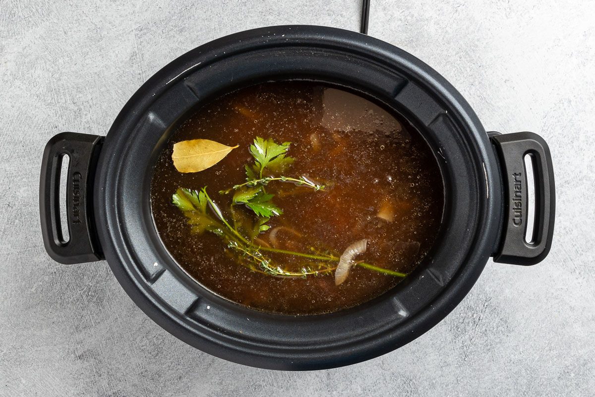 Taste of Home Crock Pot French Onion Soup recipe photo of the liquids and herbs added to the slow cooker.