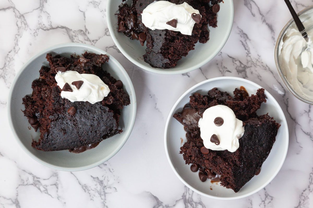 Three servings of Taste Recipes Crock-Pot Lava Cake on a white marble surface