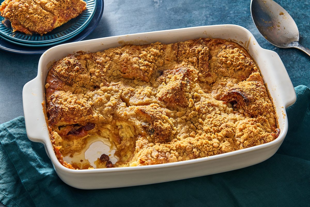 Angled shot of croissant bread pudding with a portion scooped out