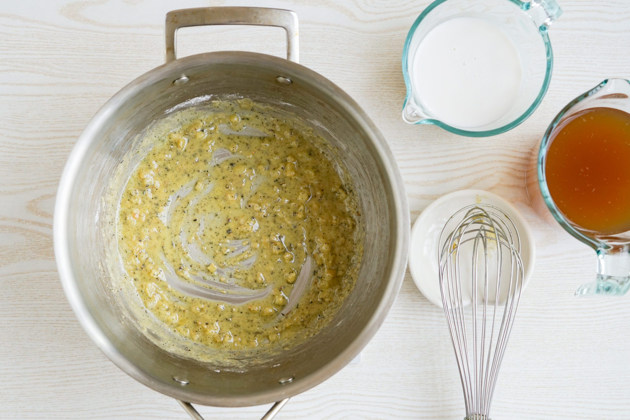 Adding broth and almond milk to roux