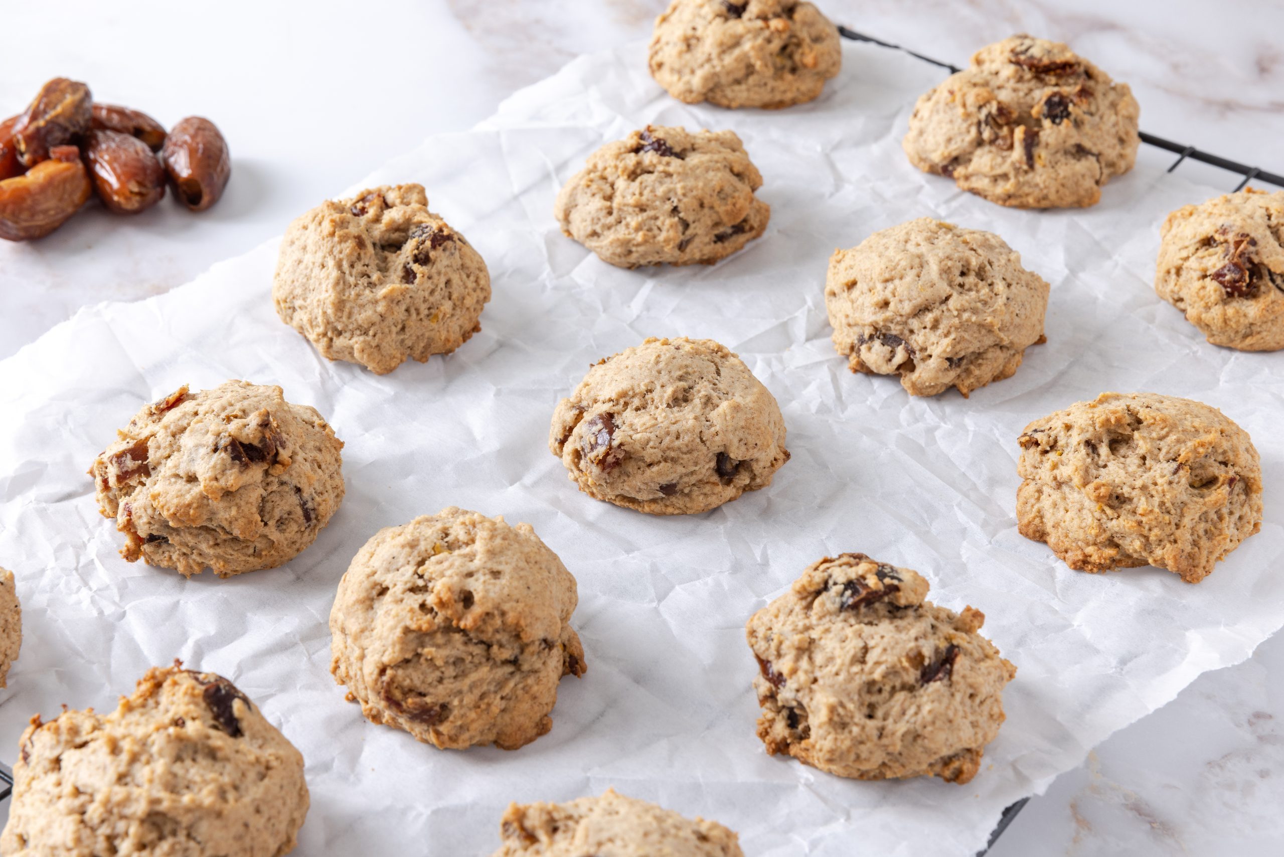 Cookies baked on parchment paper on top of wired rack.