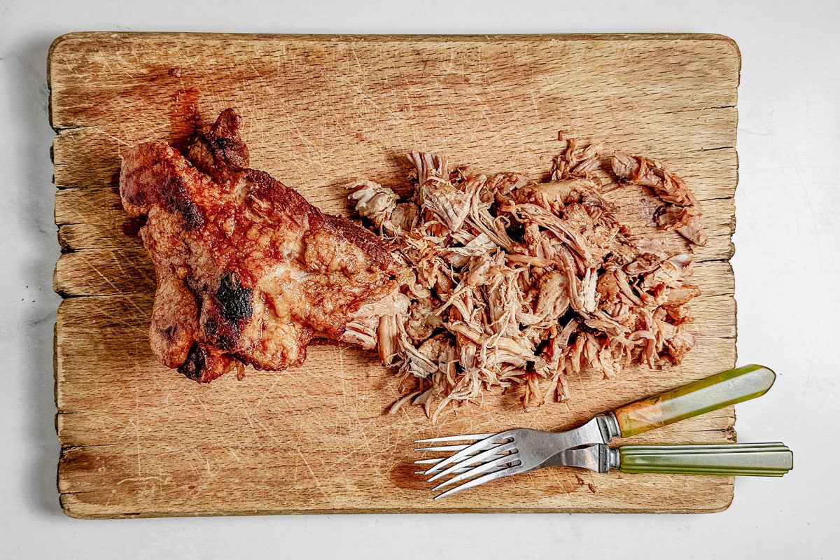 Taste of Home Dutch oven pulled pork on a wooden cutting board on a marble surface