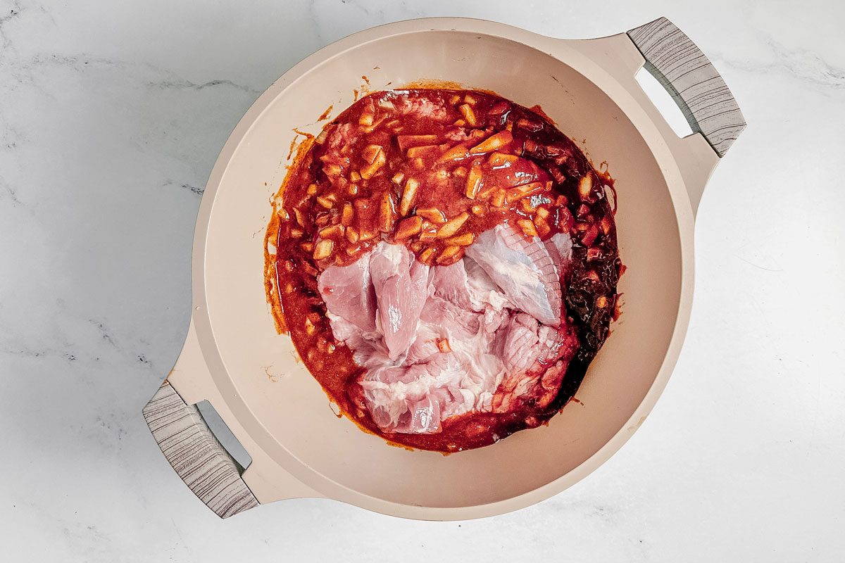 Ingredients for Taste of Home Dutch oven pulled pork in a Dutch oven on a marble surface