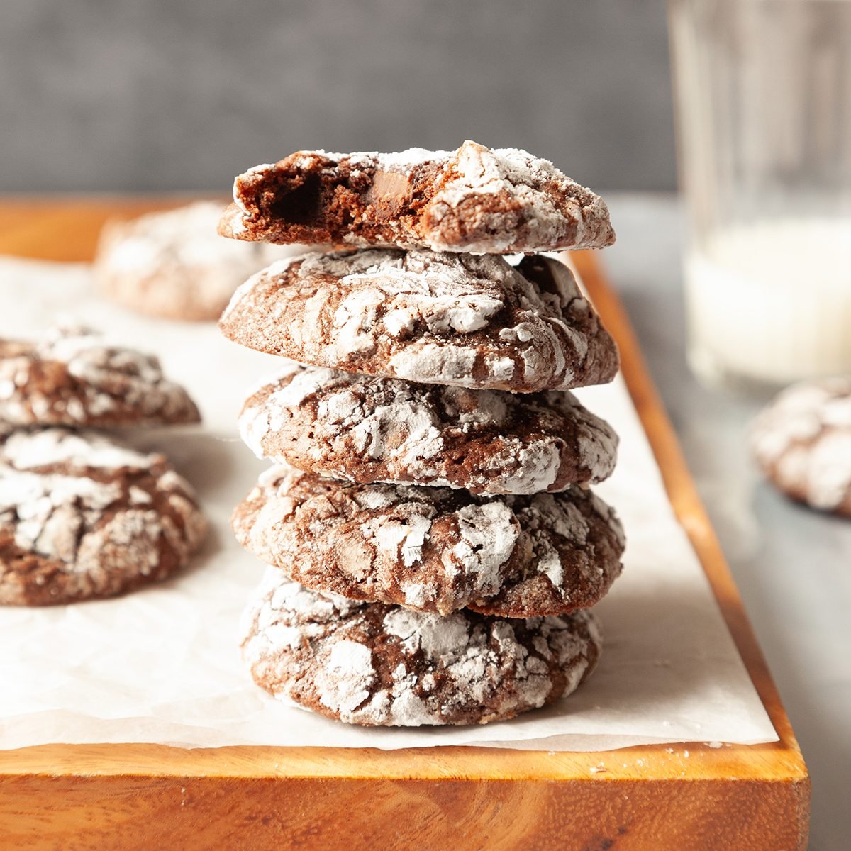 Stack of Taste of Home Brownie Mix Cookies on a wooden cutting board and a glass of milk in the background