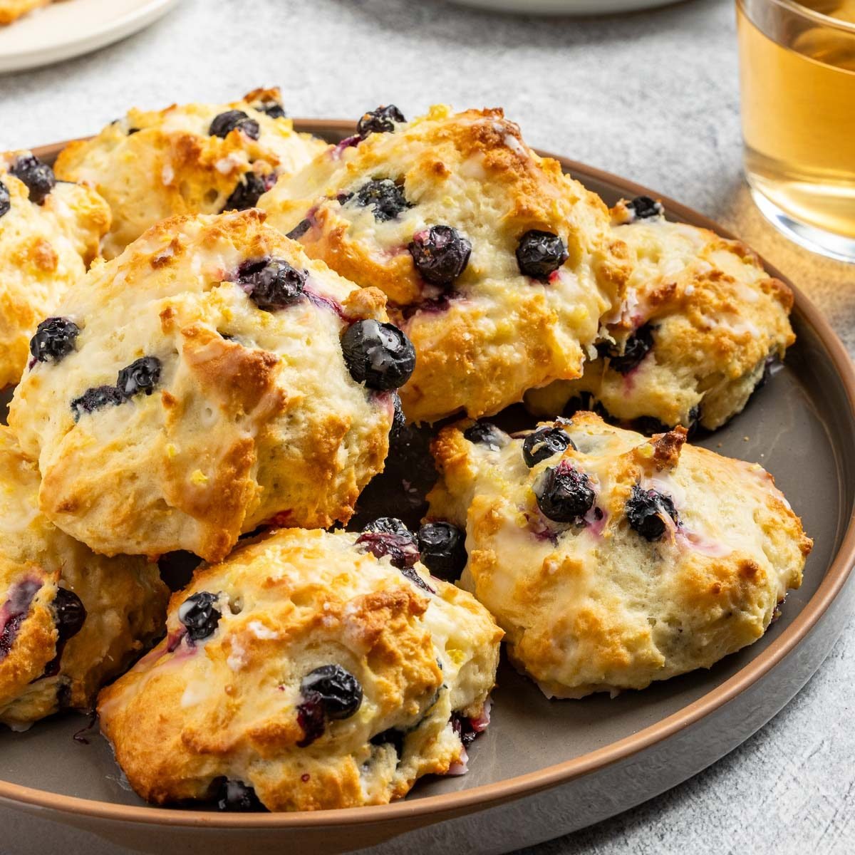 Taste of Home Lemon Blueberry Scones recipe photo of the finished scones on a serving platter and plates.