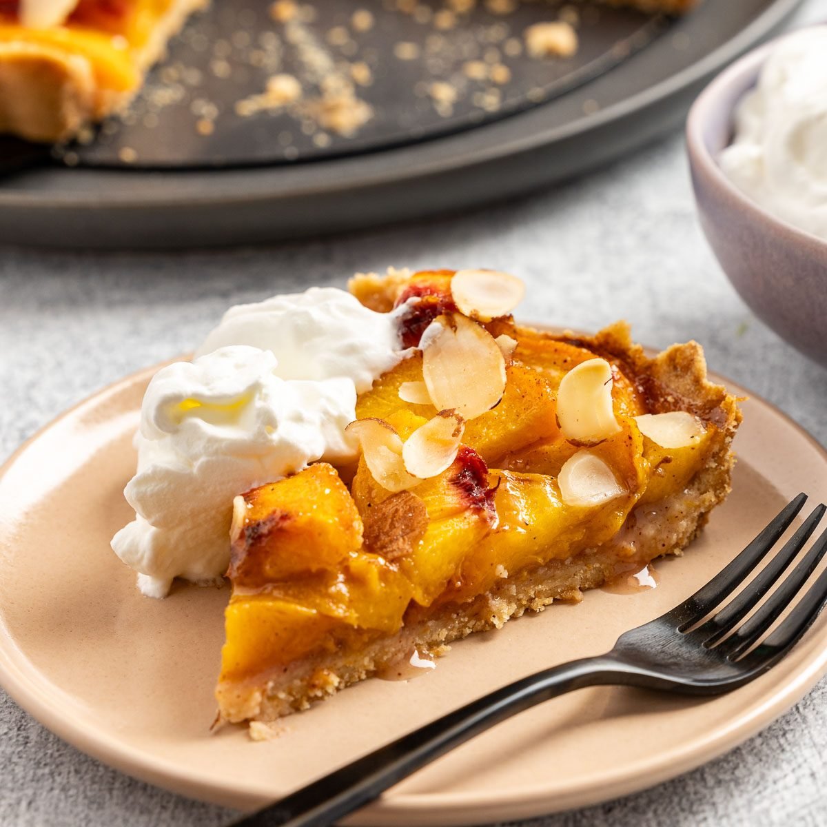 Taste of Home Peach Tart recipe photo of the peach tart cut into slices and set on plates.