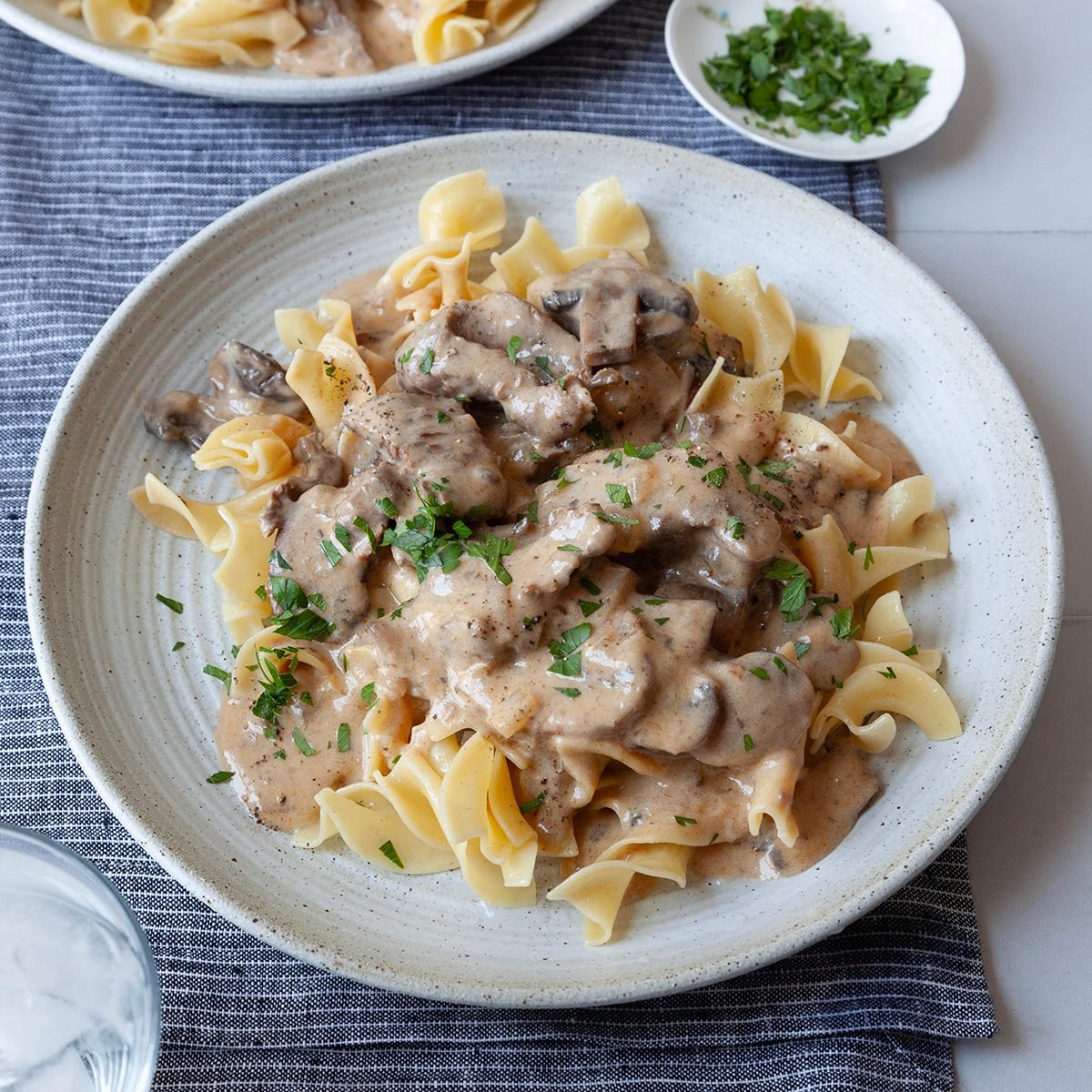 2 single servings of Taste of Home Crockpot Beef Stroganoff with egg noodles and garnished with parsley