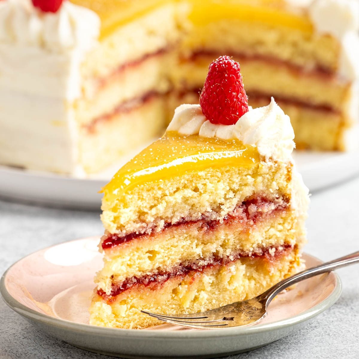 Taste of Home Lemon Raspberry Cake recipe photo of the cake cut into slices and served on plates.