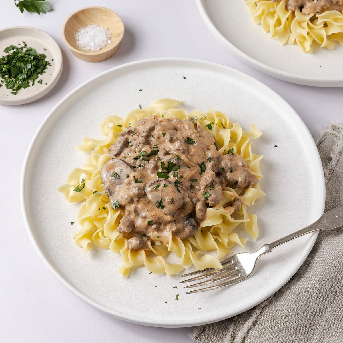 Stroganoff served on plates garnished with fresh parsley.