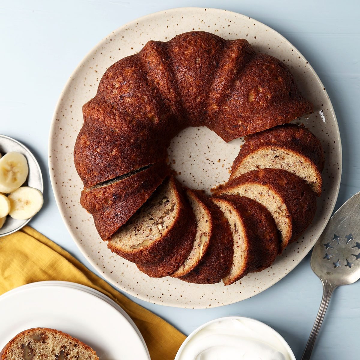 Taste of Home's Banana Bundt Cake sliced and served on a plate on a blue surface.