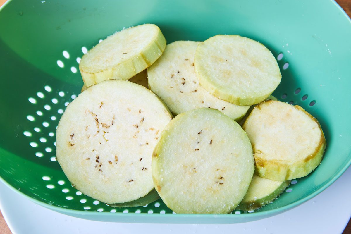 sliced eggplant in green colander