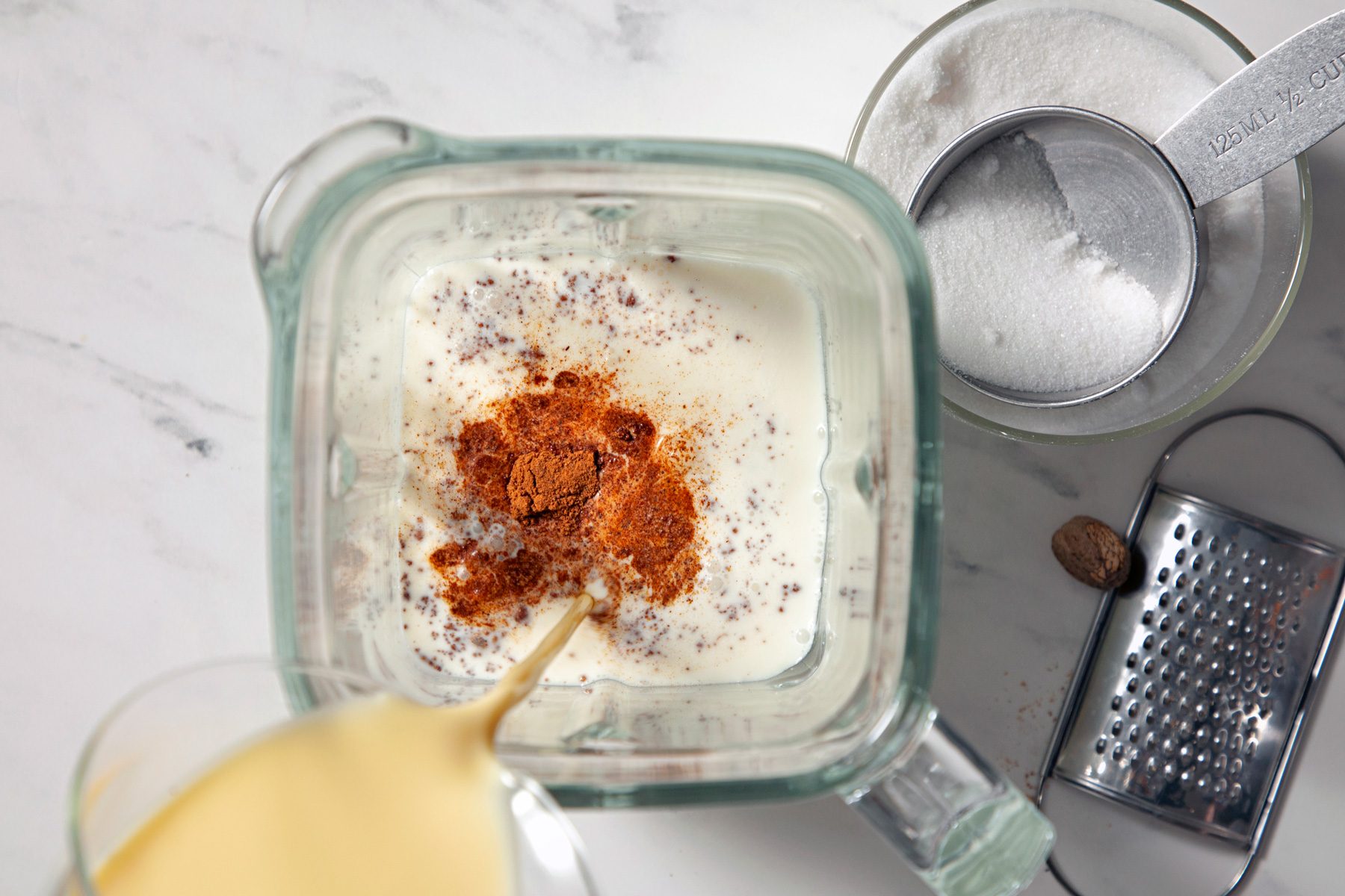 Top view shot of pouring all ingredients in the blender to make ice cream 