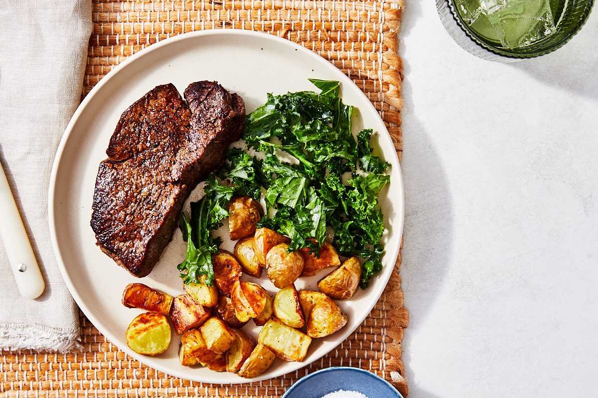 Filet Mignon Hero- whole steak plated with potatoes and greens