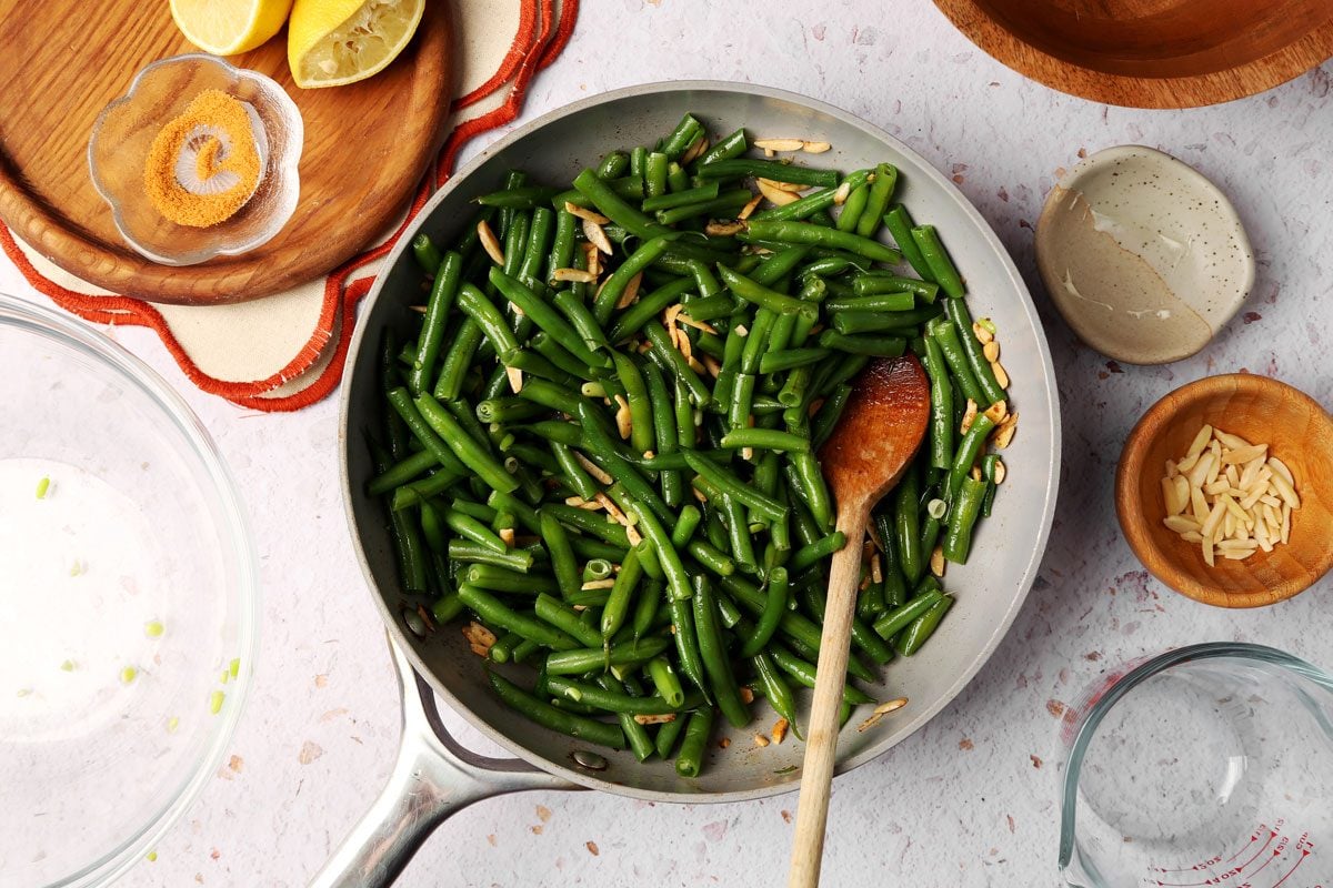 Taste of Home's Green Bean Almondine close up in a skillet being cooked.