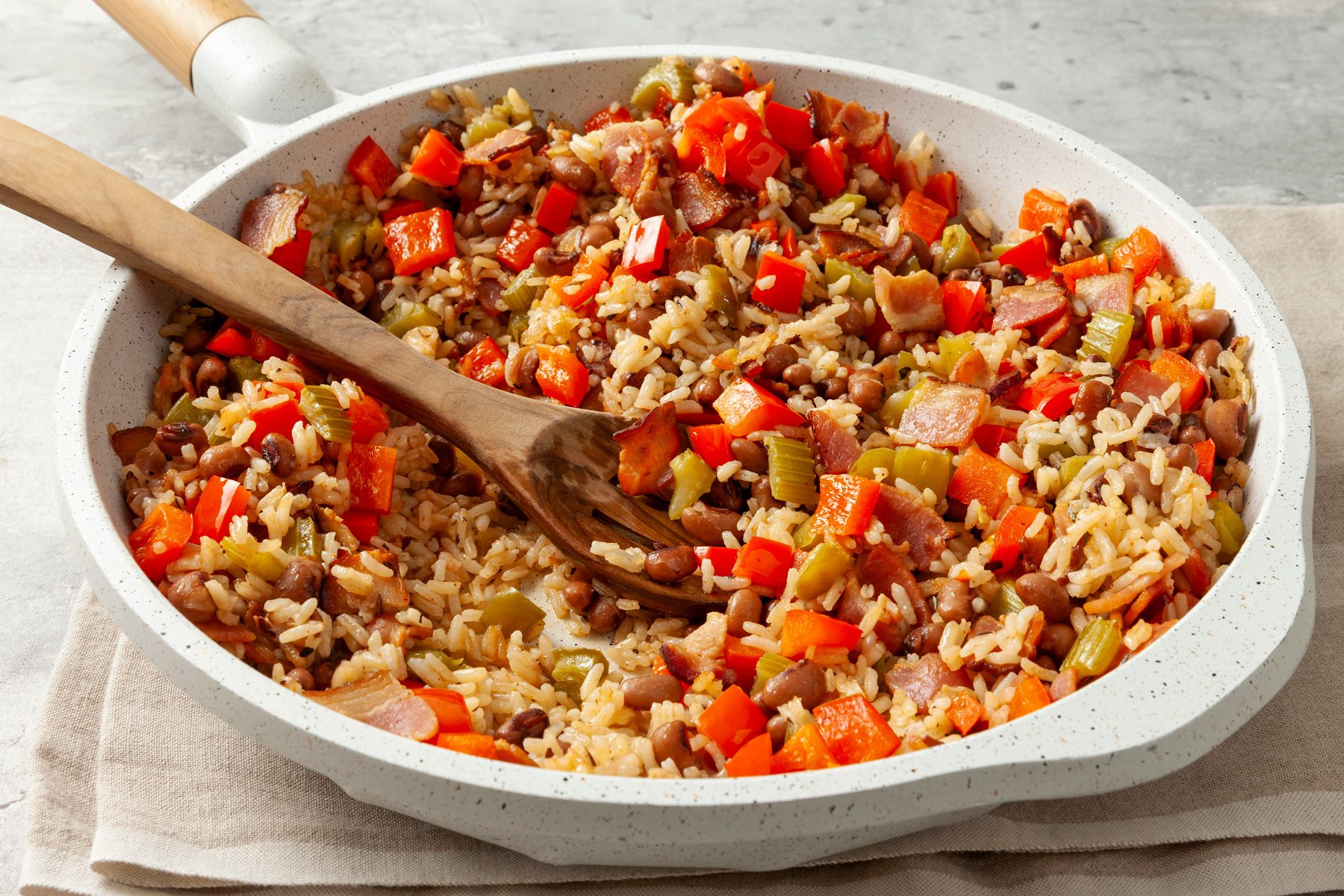 Hoppin John in large serving bowl with wooden spoon