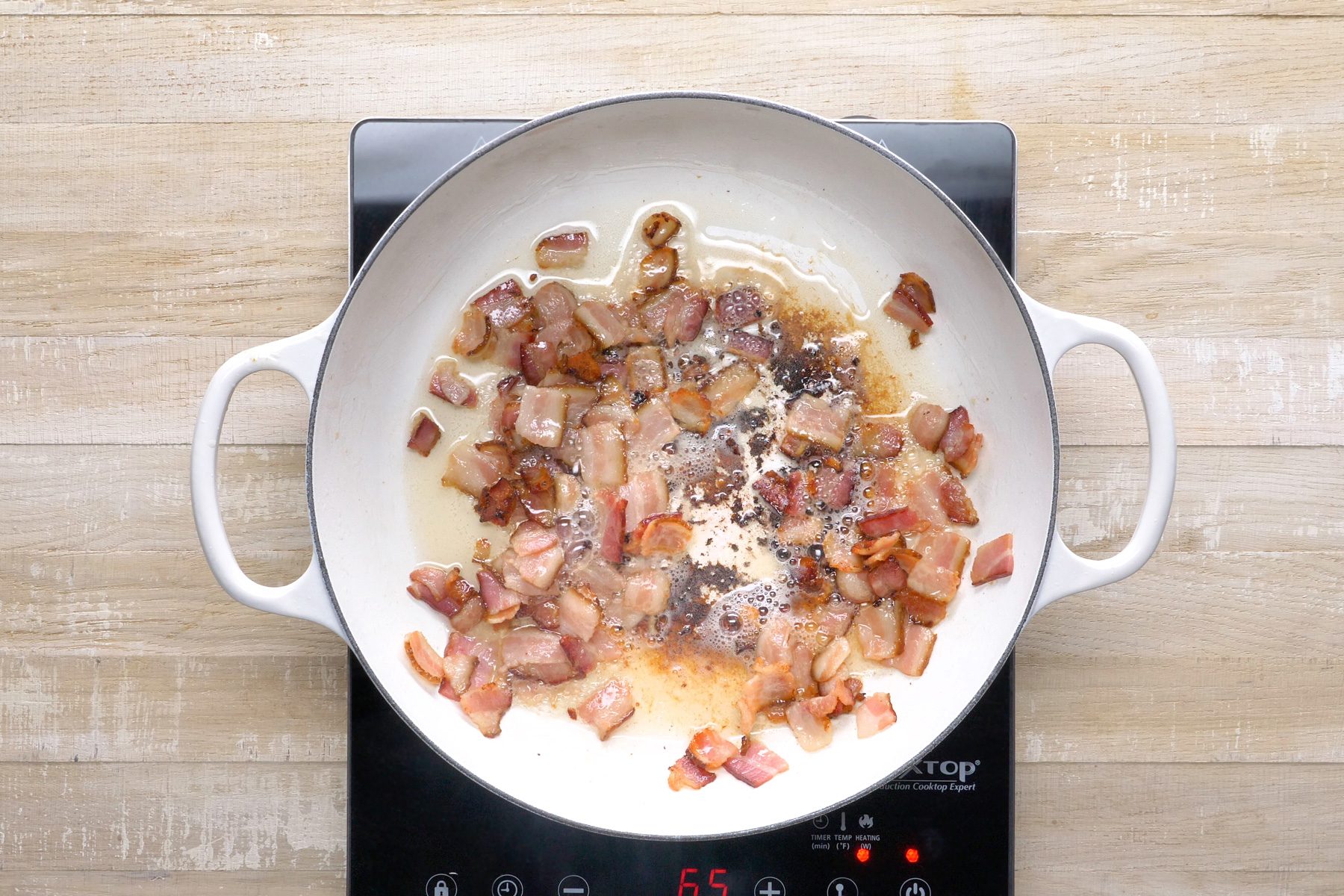 Top View shot of bacon cooking in large skillet