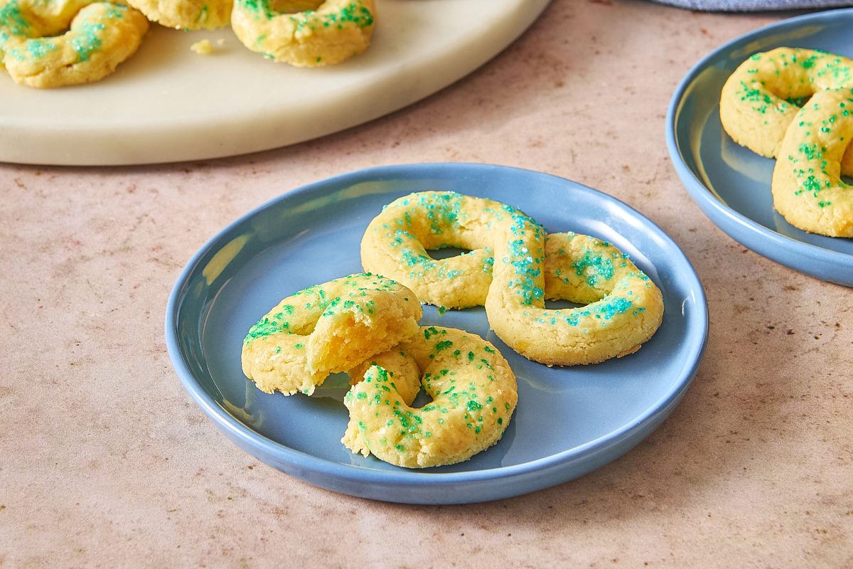 Closeup of two Italian lemon cookies on a plate with one broken in half