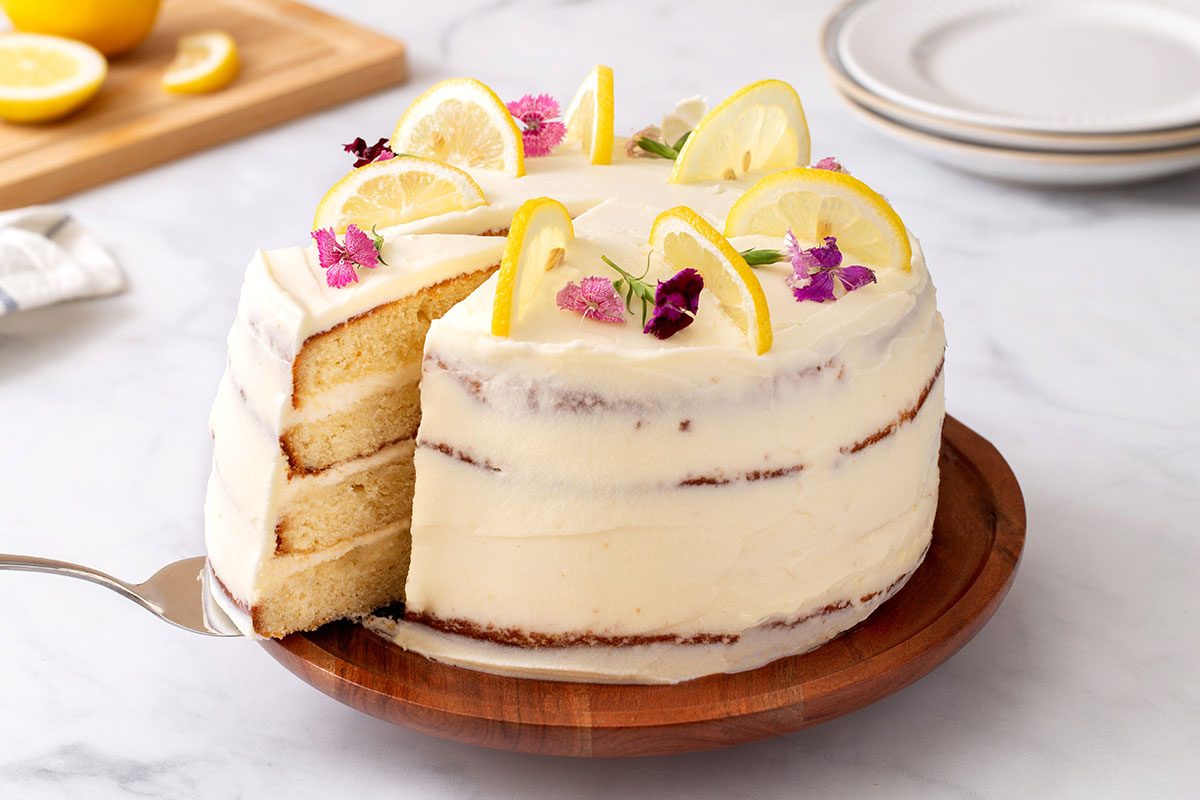 Lemon cake with slice being pulled out for Lemon Cake recipe for Taste of Home