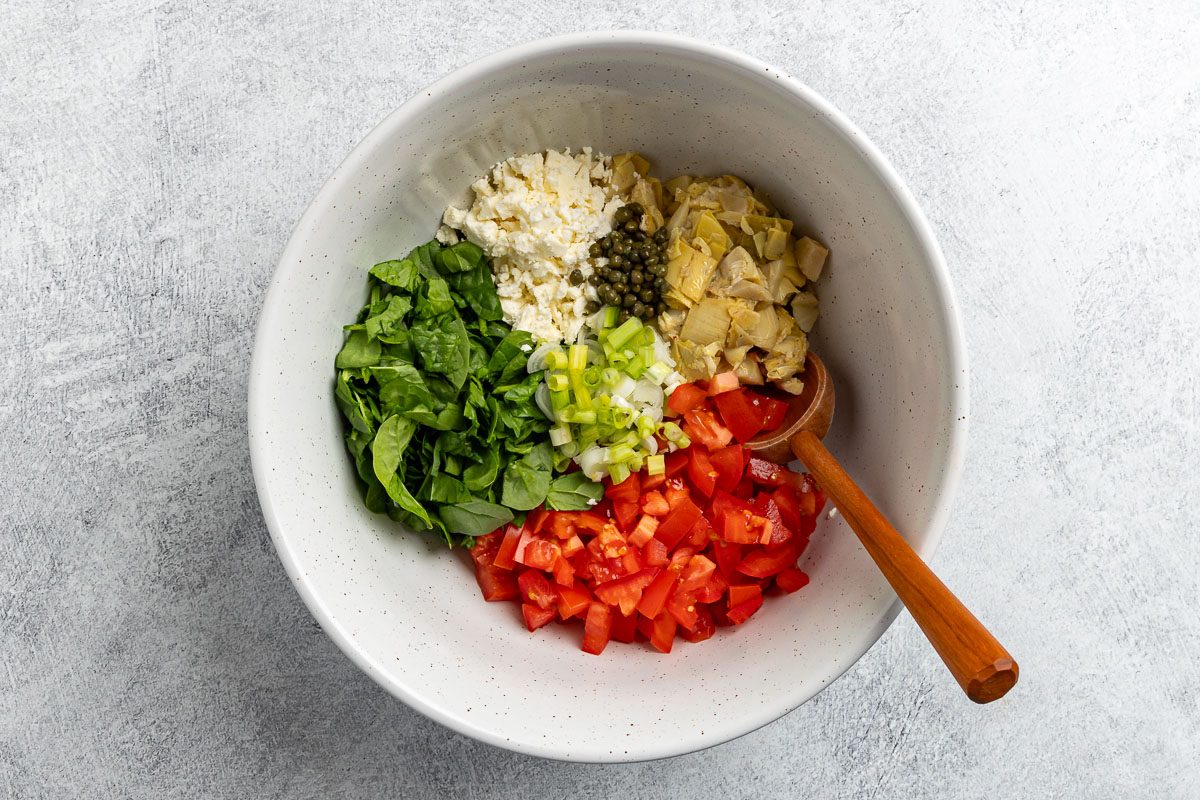 Taste of Home Lemon Orzo Salad recipe photo of vegetables salad ingredients in a large mixing bowl.