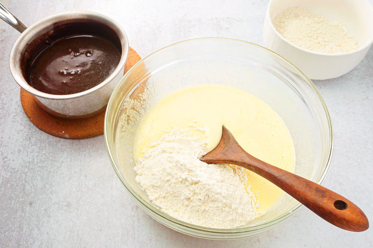 mixing wet and dry ingredients together to make frosted brownies