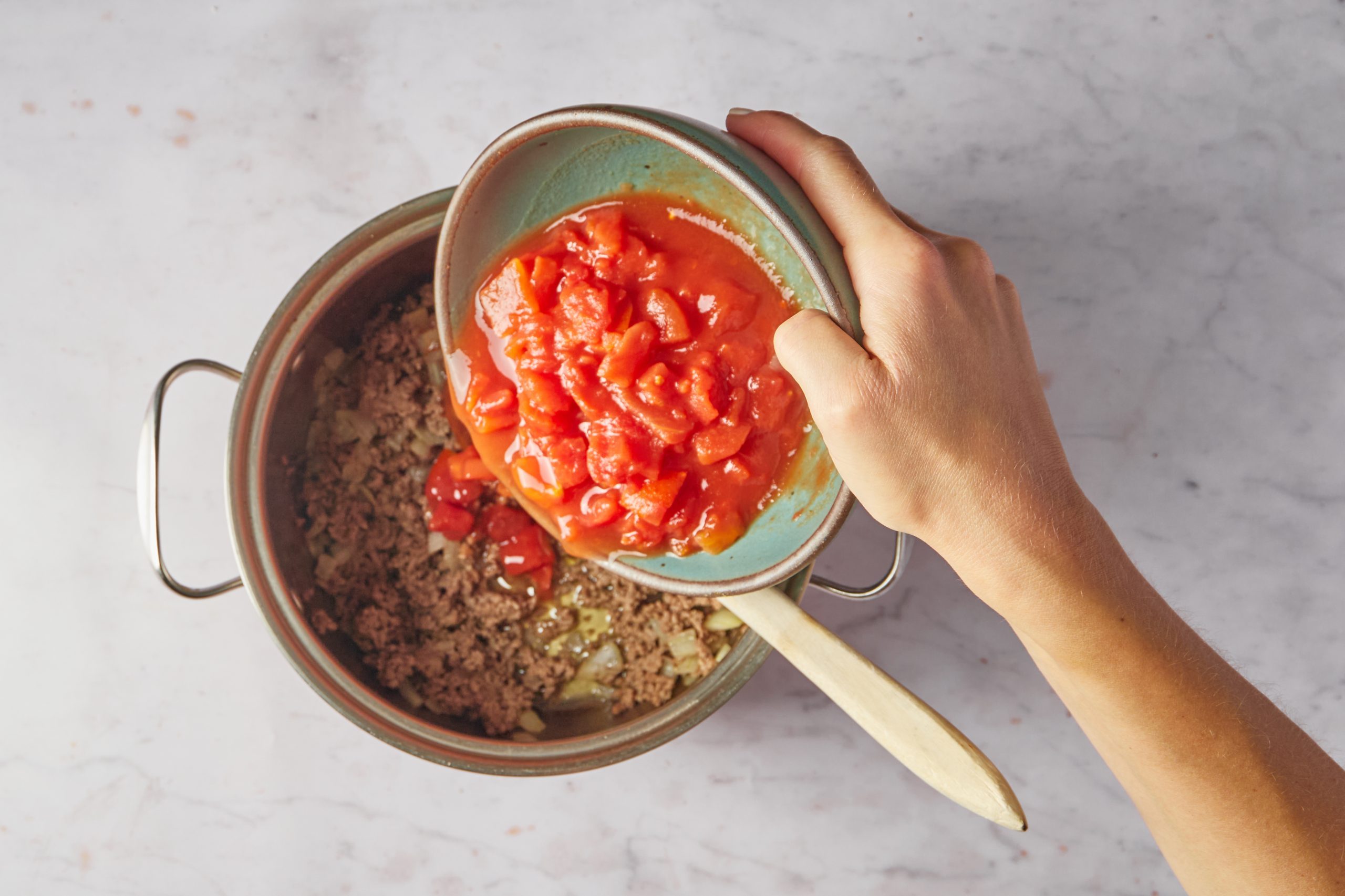 Add the tomatoes to the Mexican mac and cheese.