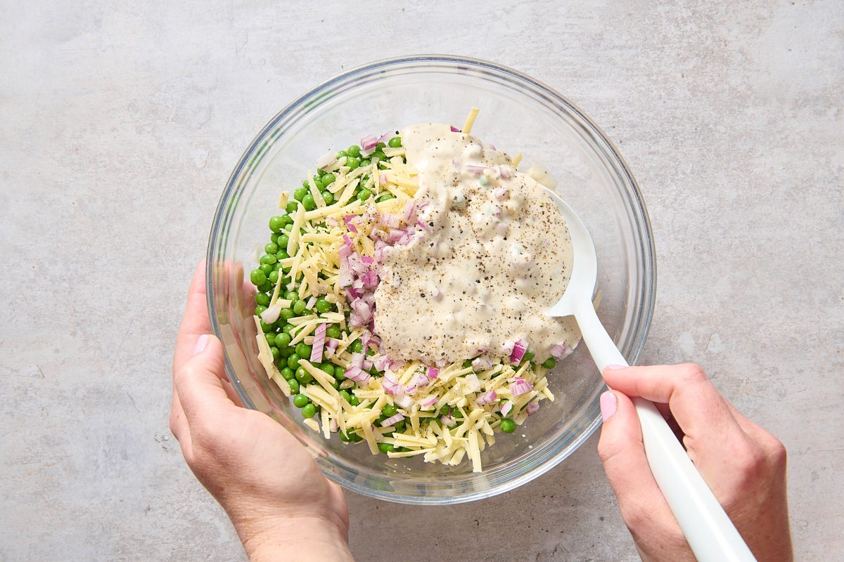 Stirring the pea salad ingredients together