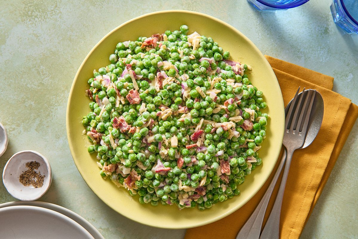 Overhead shot of pea salad with bacon served on a large plate